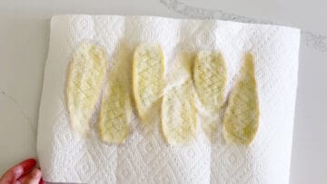 Blotting the squash dry with paper towels.