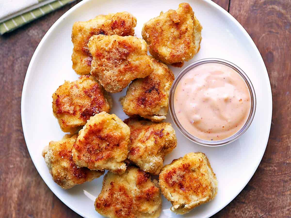 Keto chicken nuggets served with  a dipping sauce. 