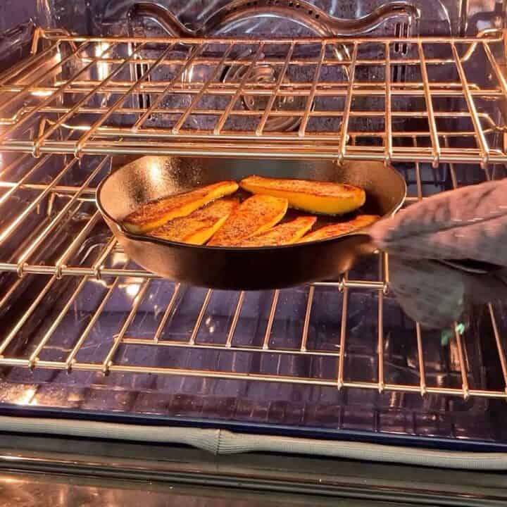 Placing squash in the oven. 