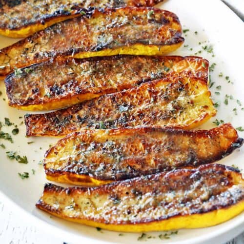 Roasted yellow squash on a white plate.