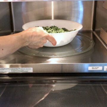 Defrosting frozen spinach in the microwave.