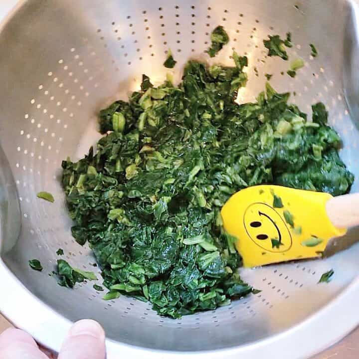 Removing excess water from the spinach.