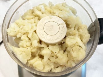 Adding the cauliflower to the food processor.