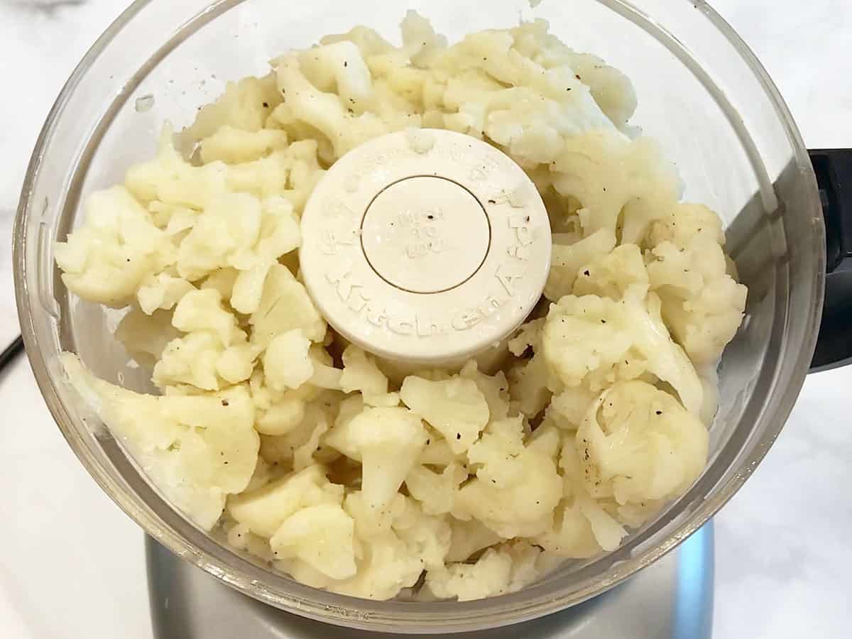 Adding the cauliflower to the food processor's bowl. 