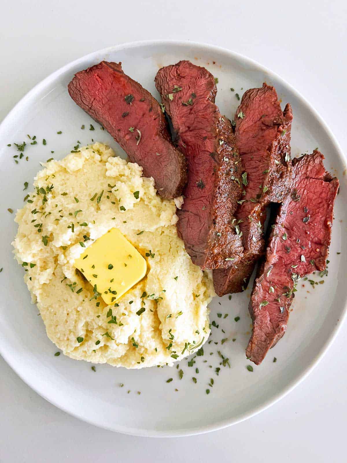 Flat iron steak served with a side of mashed cauliflower. 