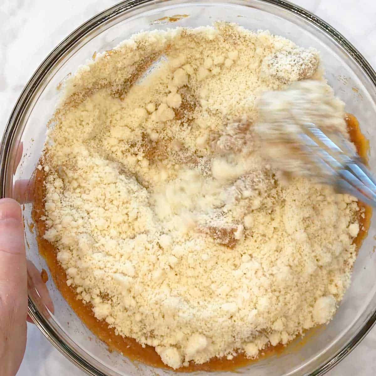 Adding almond flour to pumpkin bread batter. 