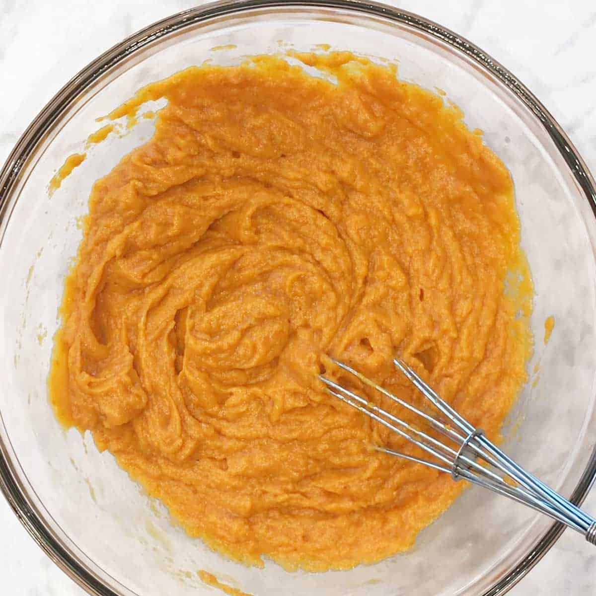 The eggs and pumpkin puree are mixed together. 