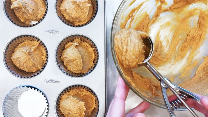 Scooping the batter into the muffin pan.