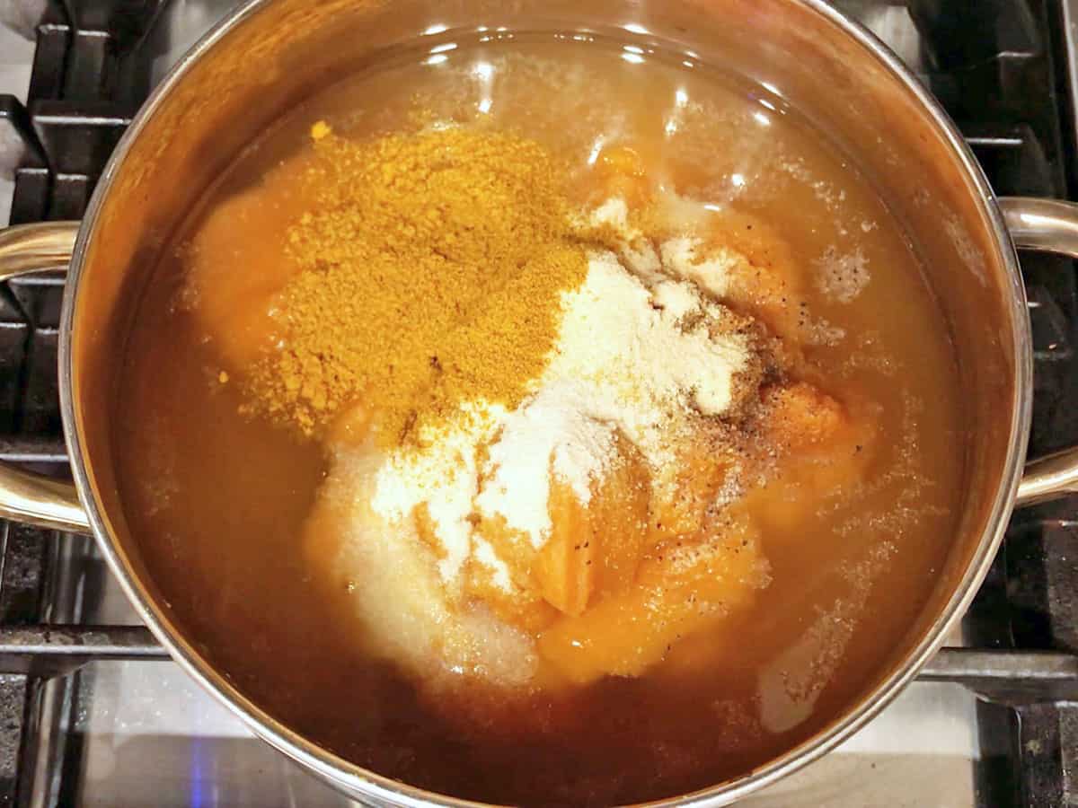 Pumpkin curry soup ingredients in a saucepan. 