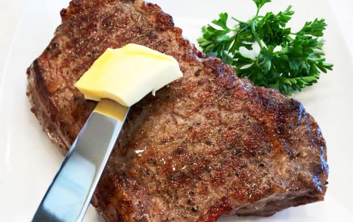 Reverse-seared steak is topped with butter.