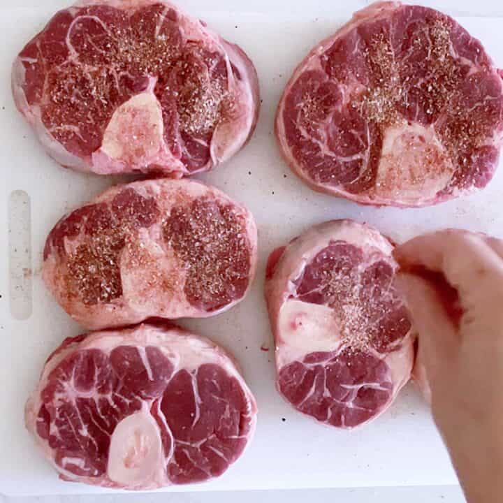 Seasoning beef shanks.