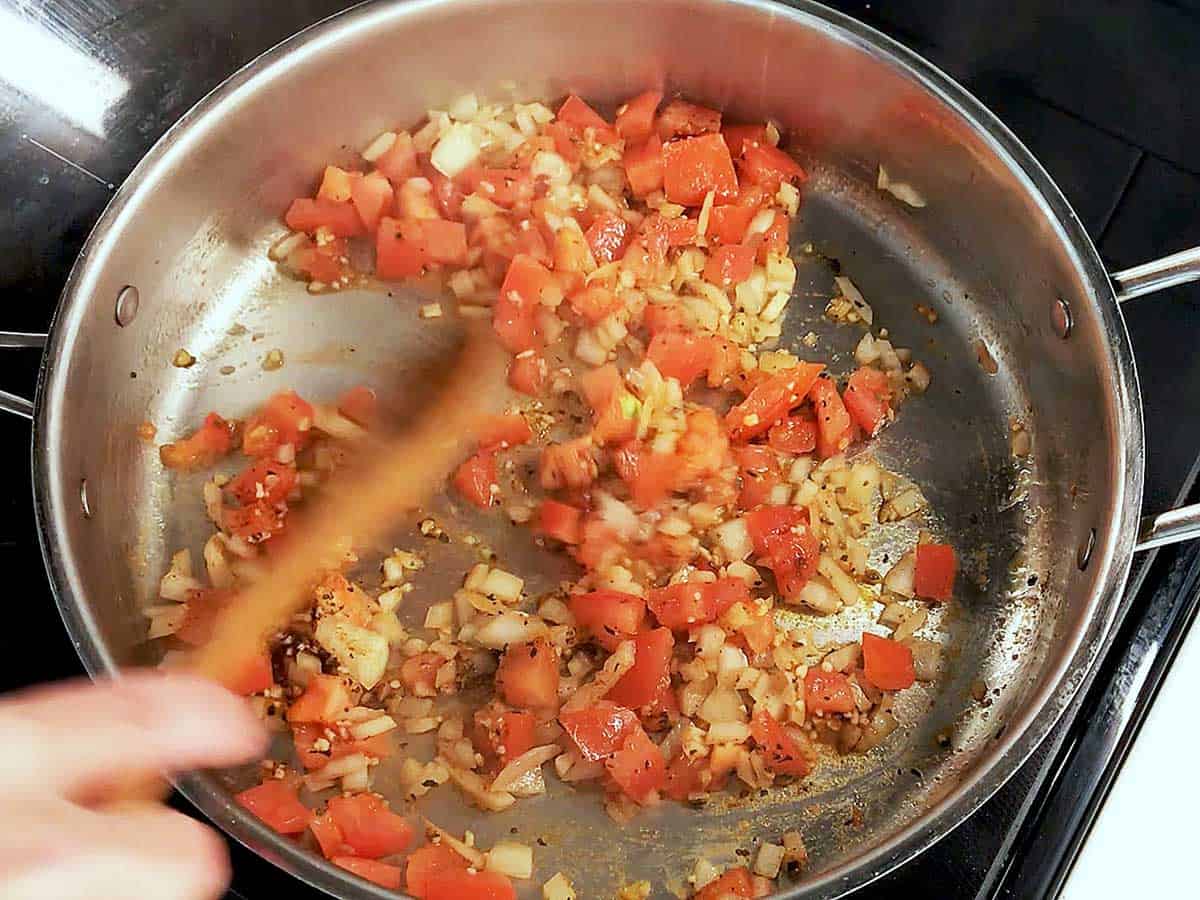 Cooking tomatoes, onions, garlic, and spices. 