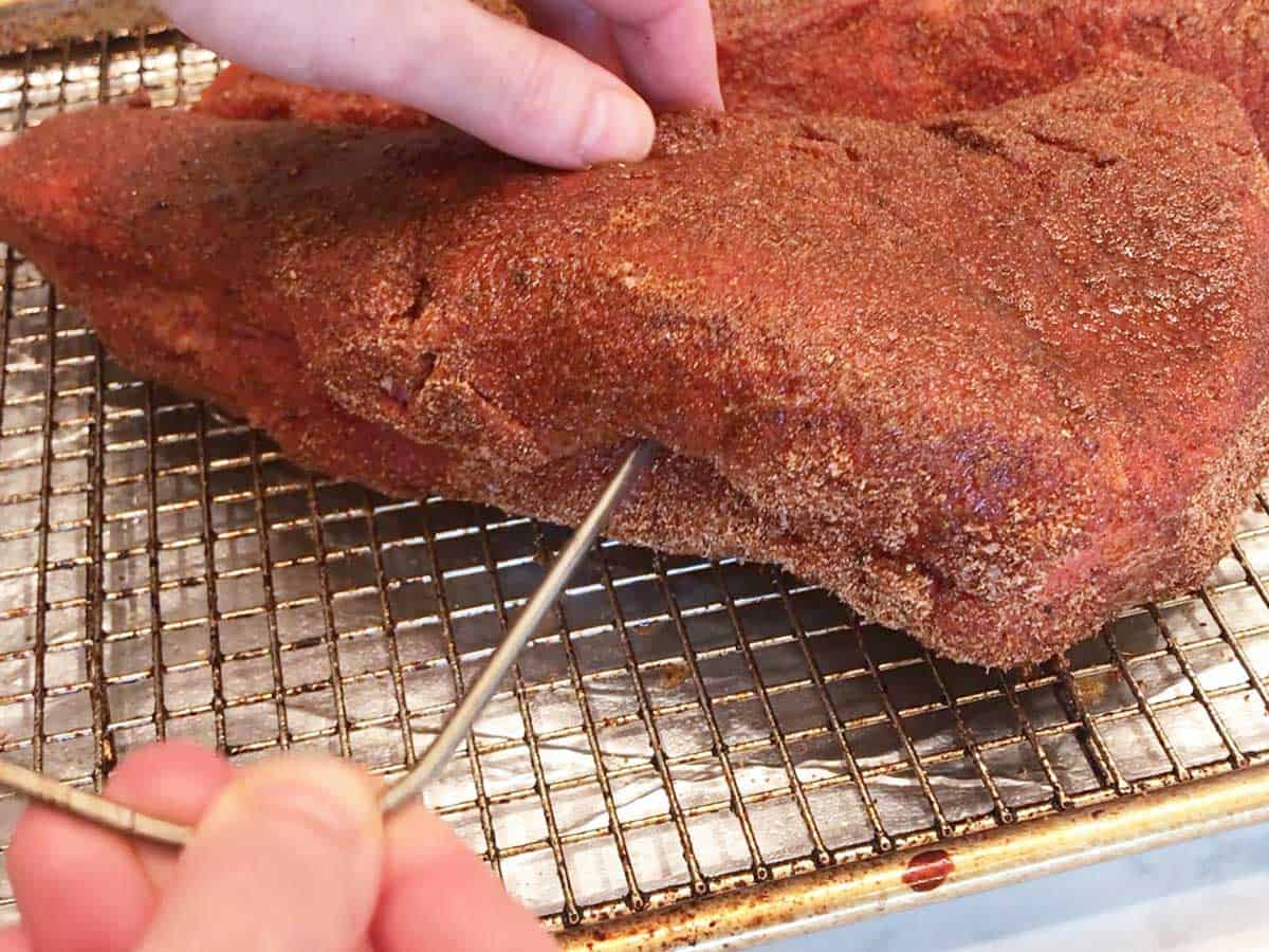 Inserting a meat thermometer into the roast. 