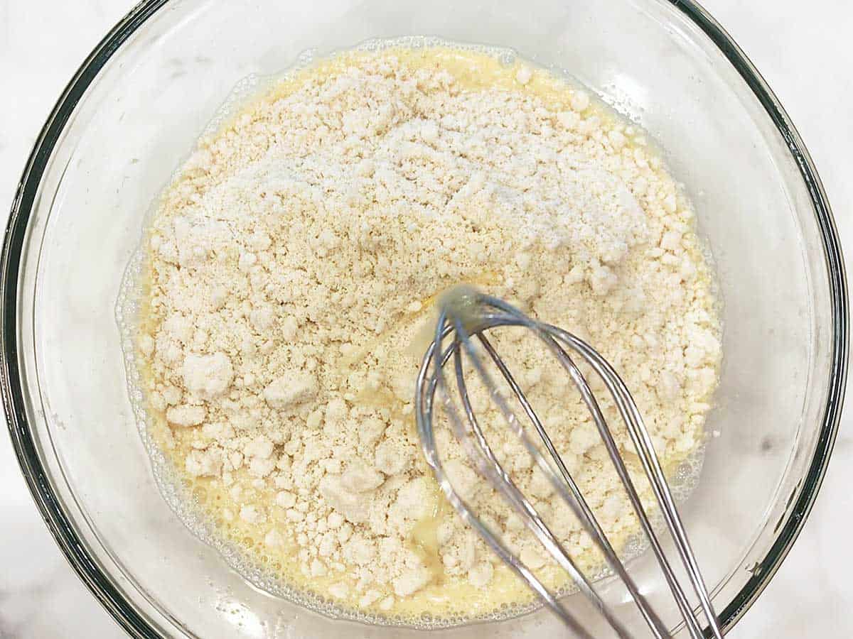 Adding almond flour to the batter. 