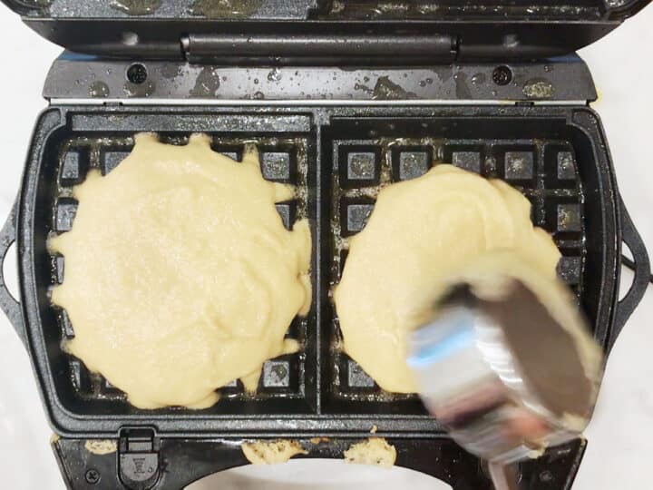 Adding batter to waffle maker.