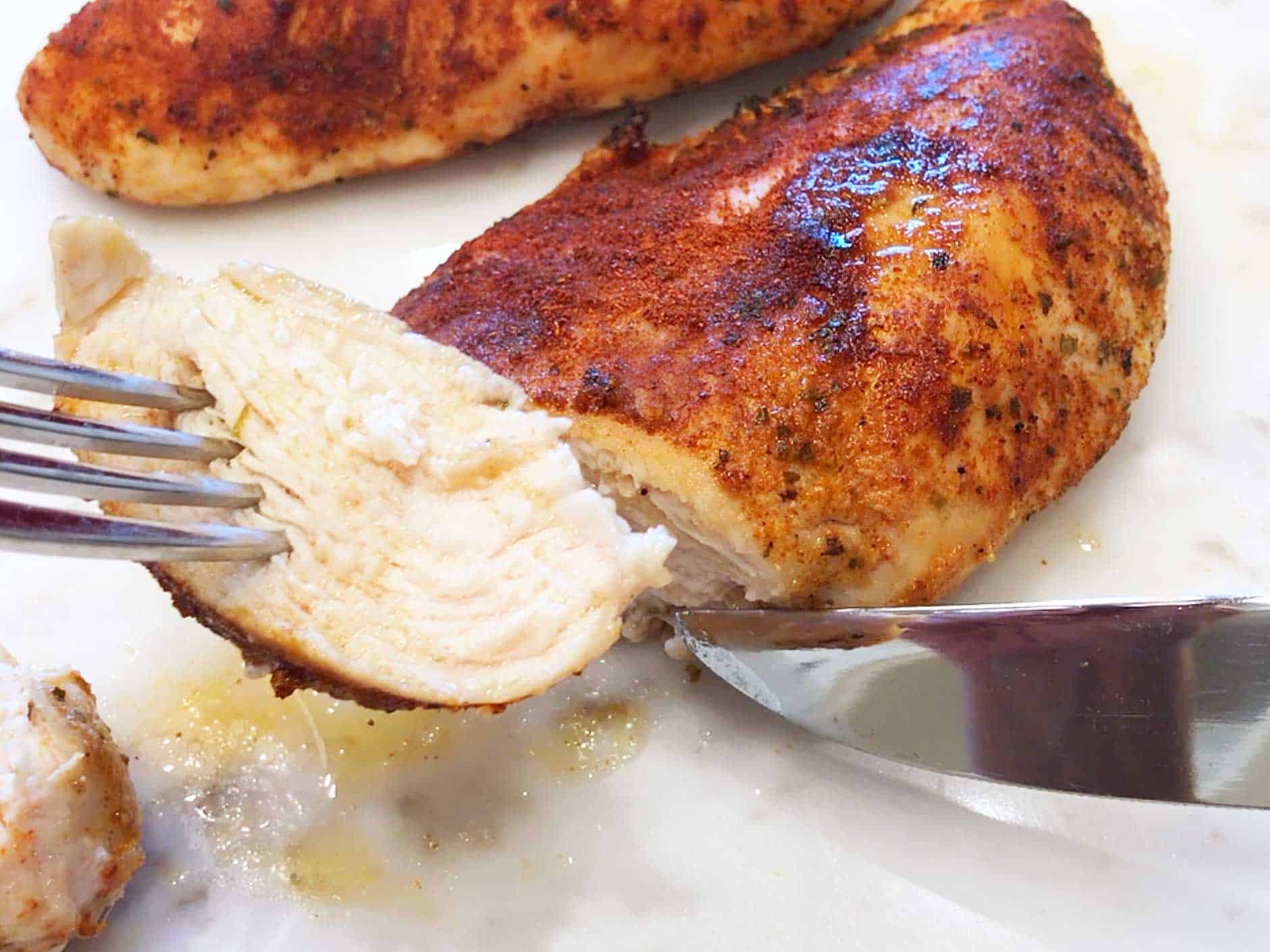 A baked chicken breast sliced to show how juicy it is. 