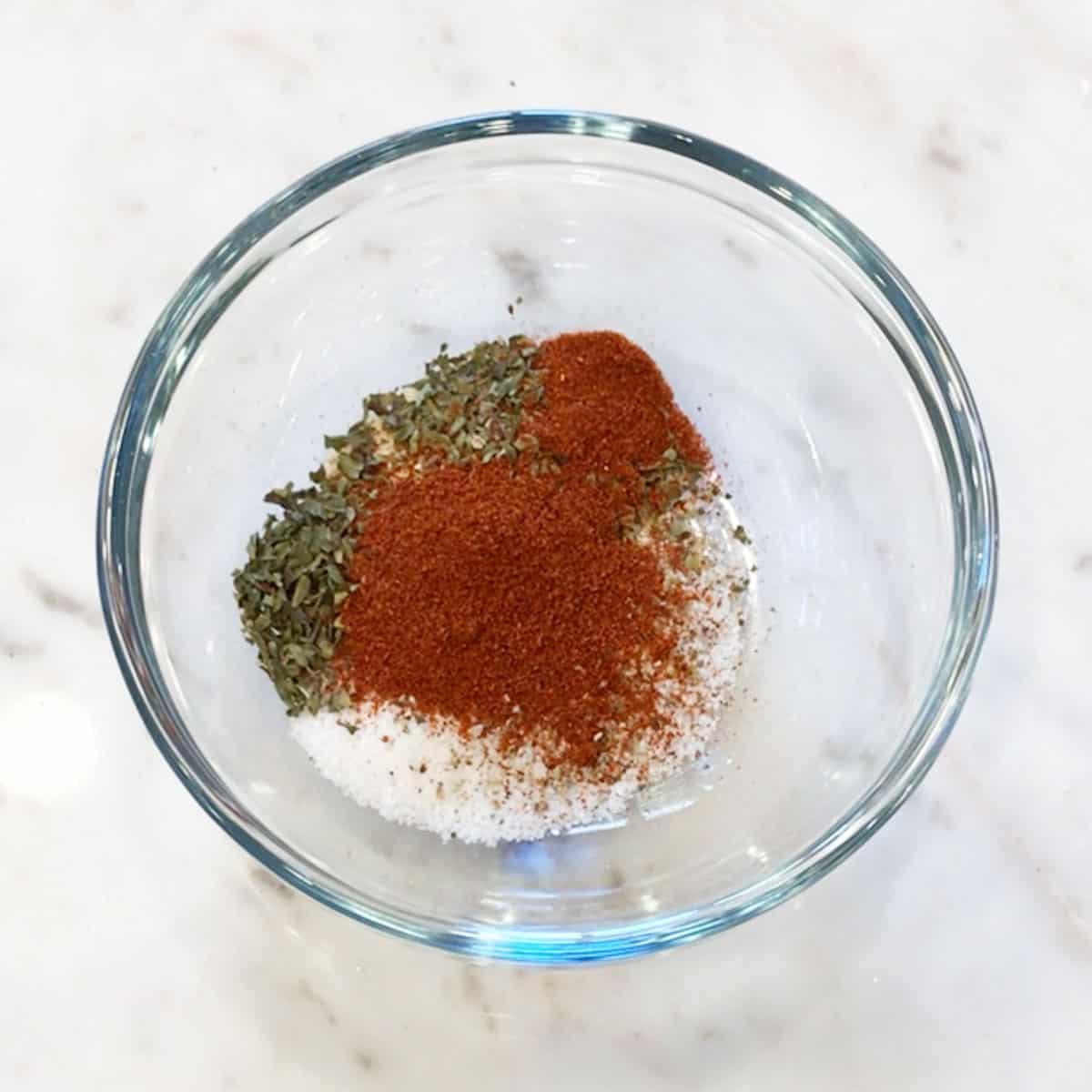 A small bowl with the spices used to bake chicken breast.