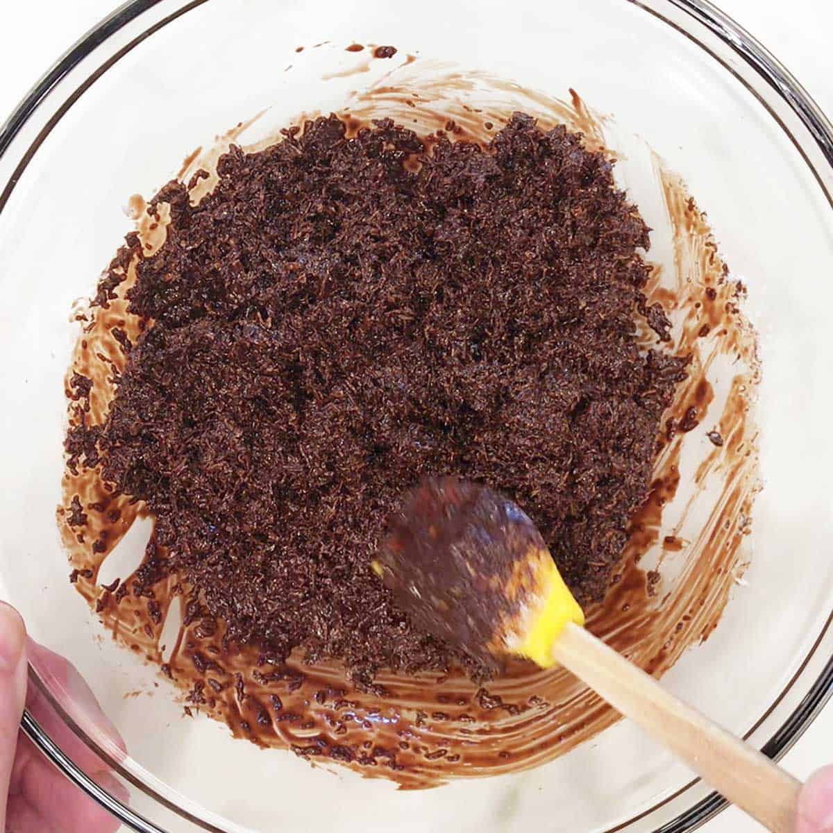 The shredded coconut is mixed thoroughly into the melted chocolate. 