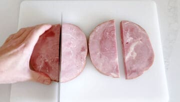Cutting ham steaks in half.