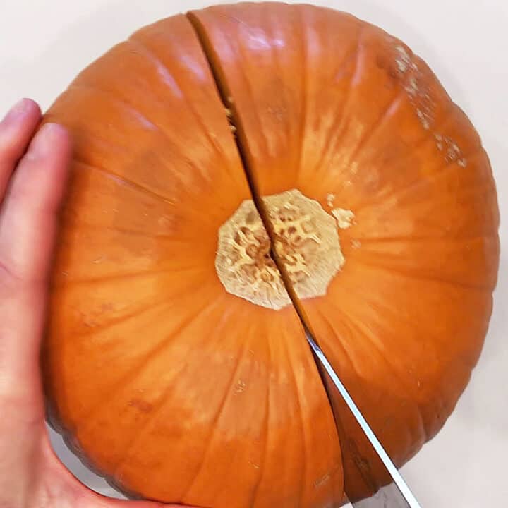 Cutting the pumpkin in half.