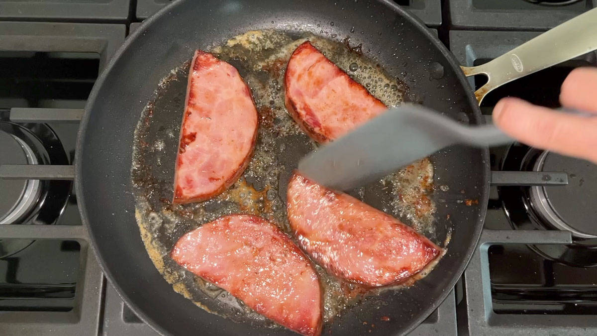 Flipping ham steak in the skillet. 