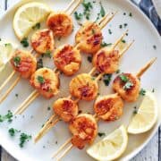 Grilled scallops served with lemon slices.