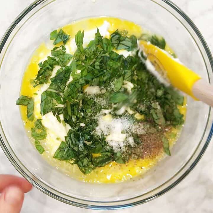 Mixing ricotta, eggs, and basil.