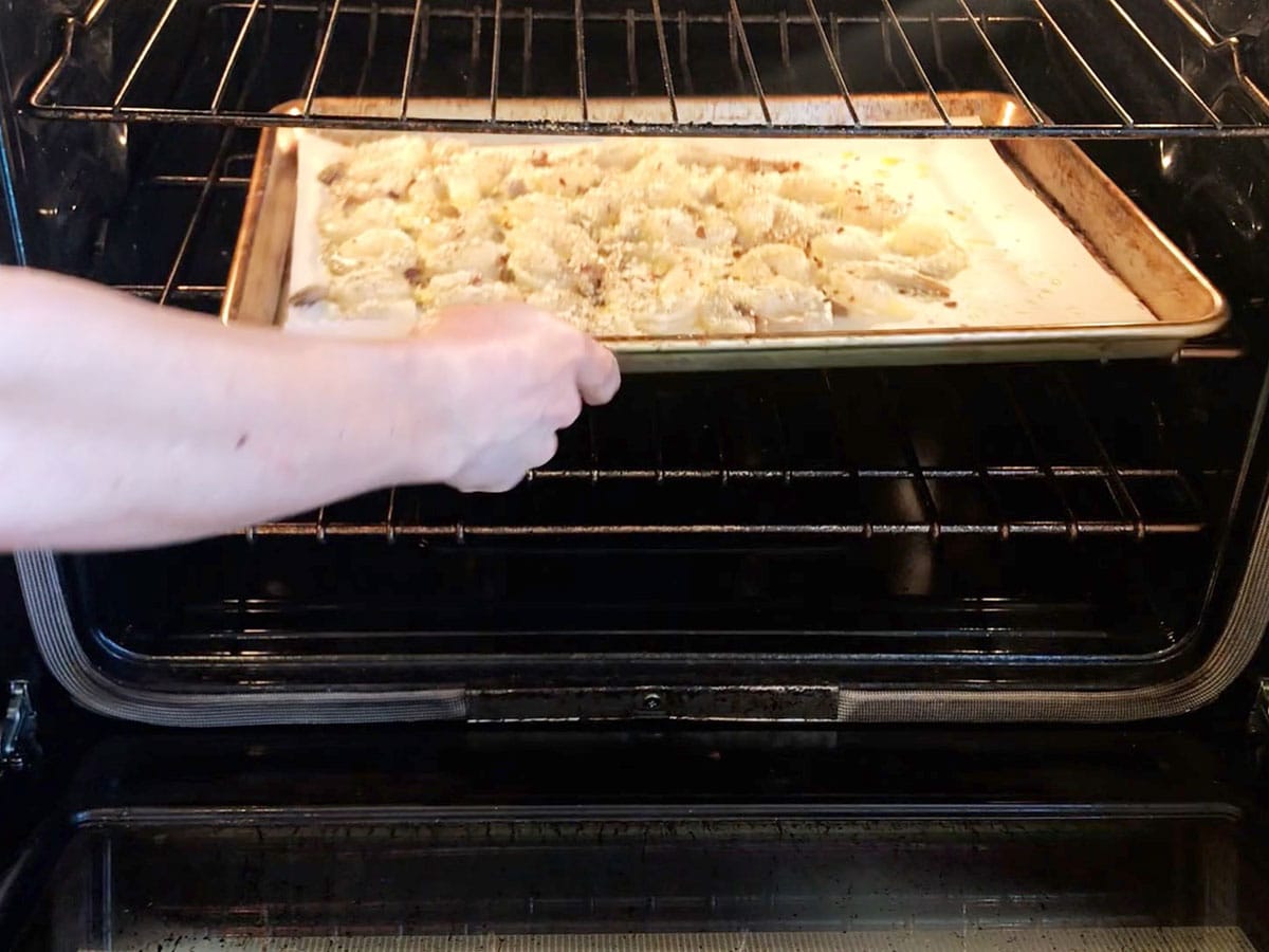 Placing shrimp in the oven. 