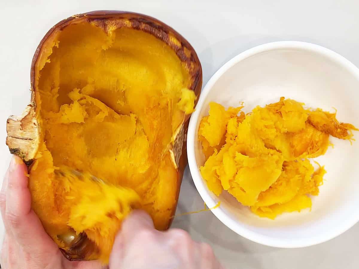 Removing the pumpkin flesh into a bowl. 