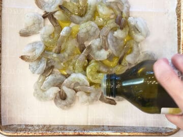 Coating shrimp in olive oil.