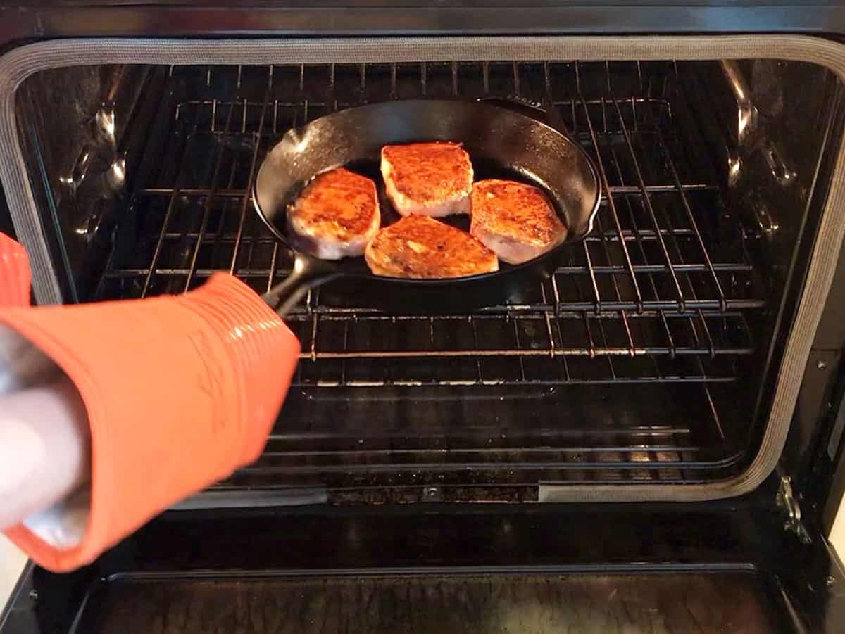 Placing the pork chops into the oven. 