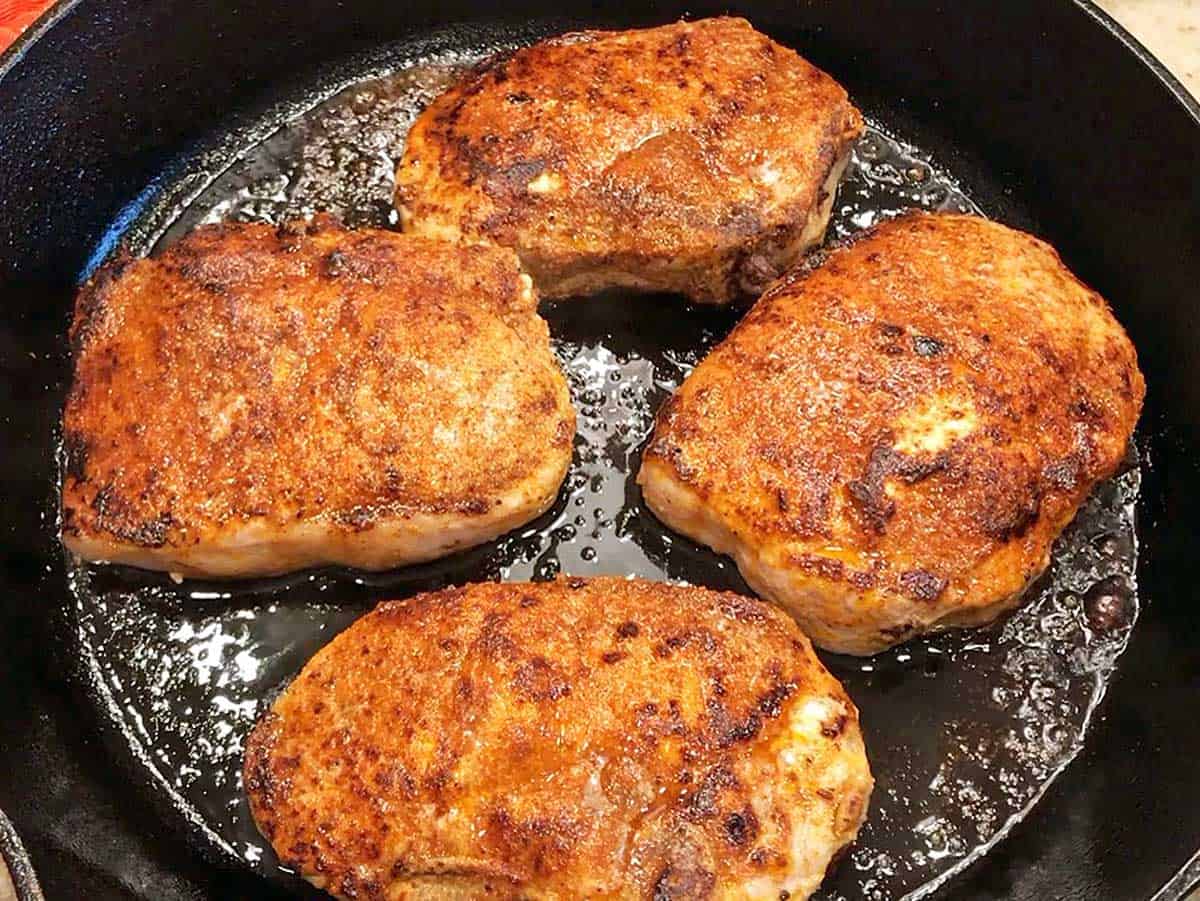 The baked pork chops are ready in the skillet. 