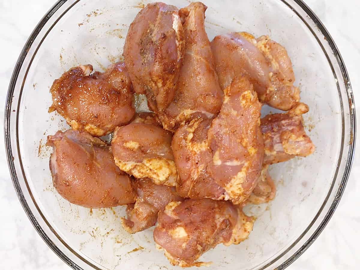 Boneless chicken thighs are coated in spices.