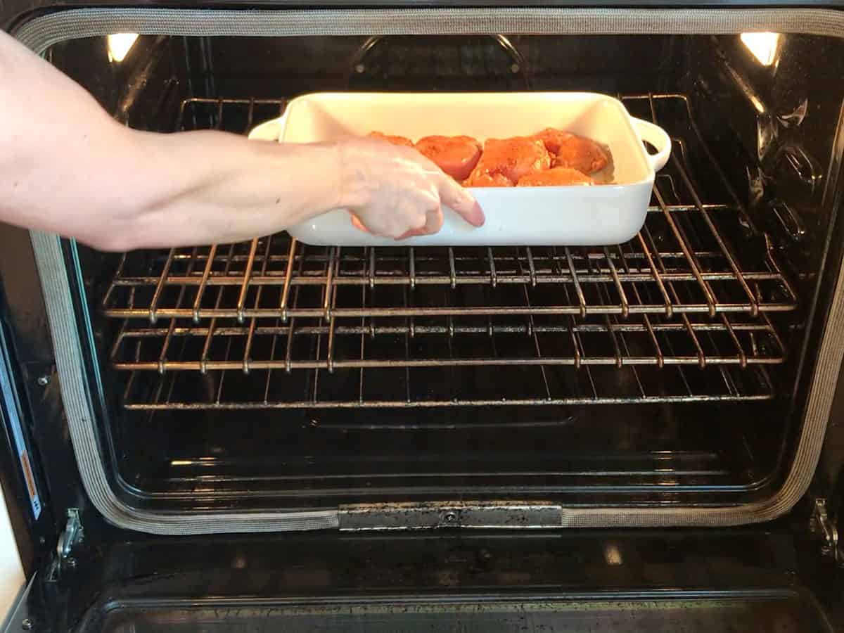 Placing boneless chicken thighs in oven.
