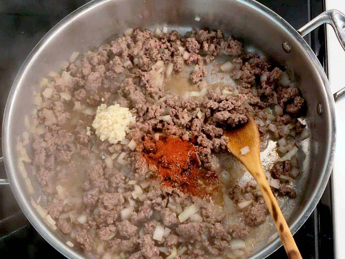 Cooking ground beef, onions, garlic, and spices in olive oil in a skillet. 