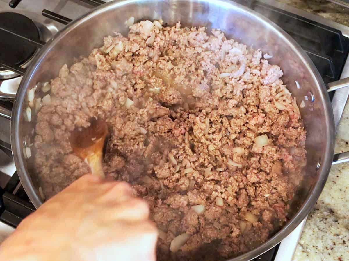 The ground beef is cooked in the skillet. 