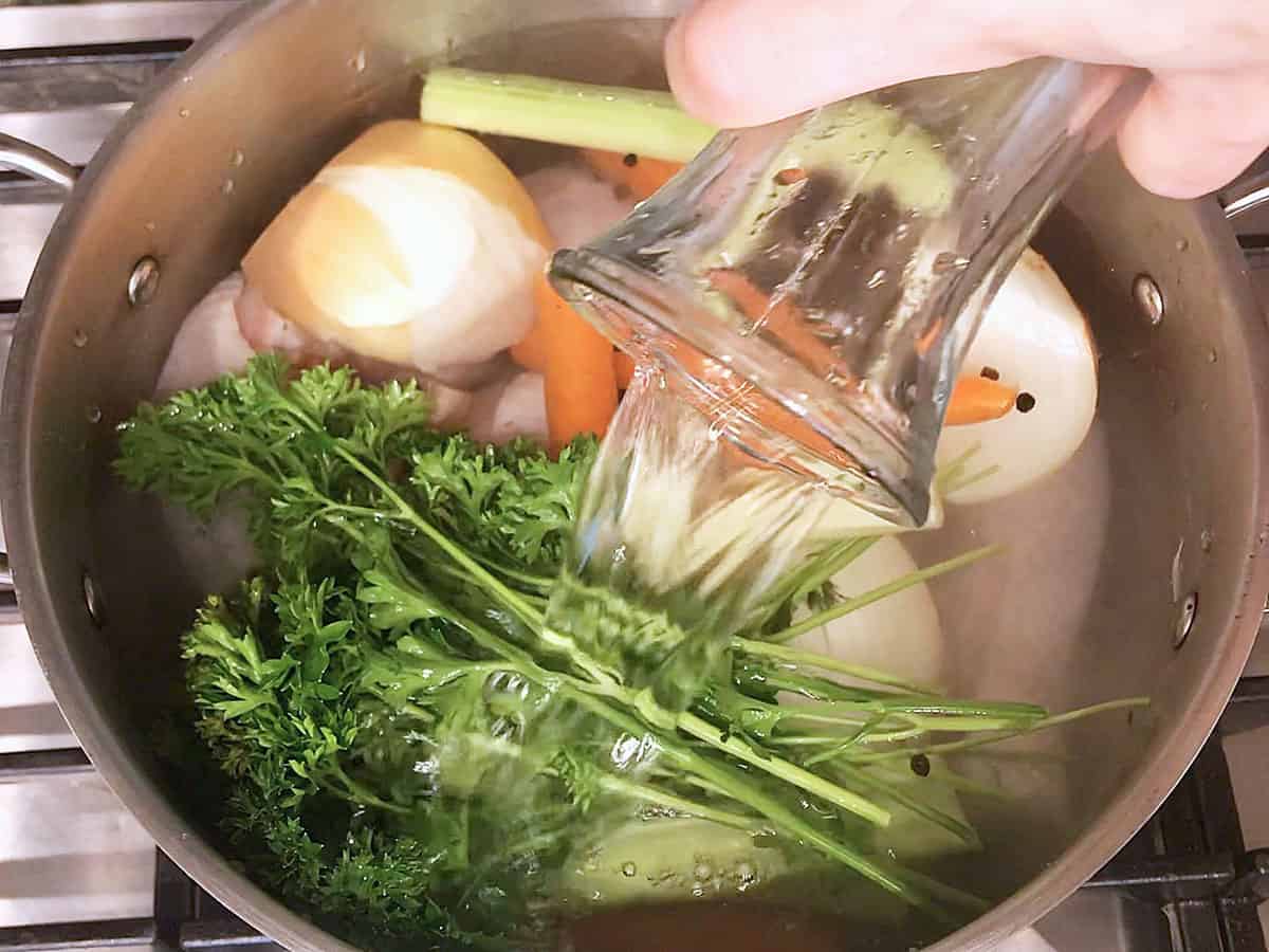 Adding water to the stockpot.