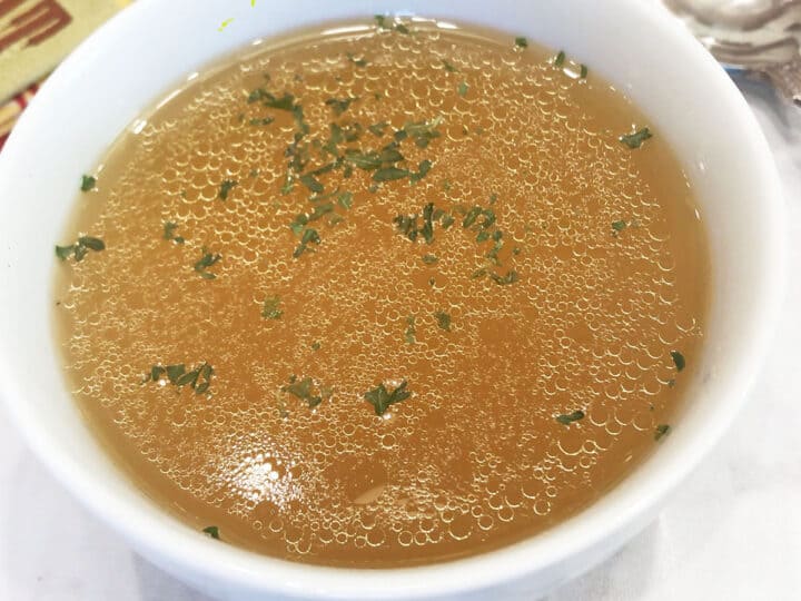 Chicken broth is served in a bowl.