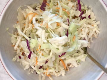 Adding cabbage to the bowl.
