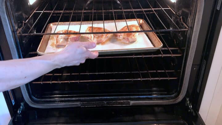 Placing the chicken thighs in the oven.