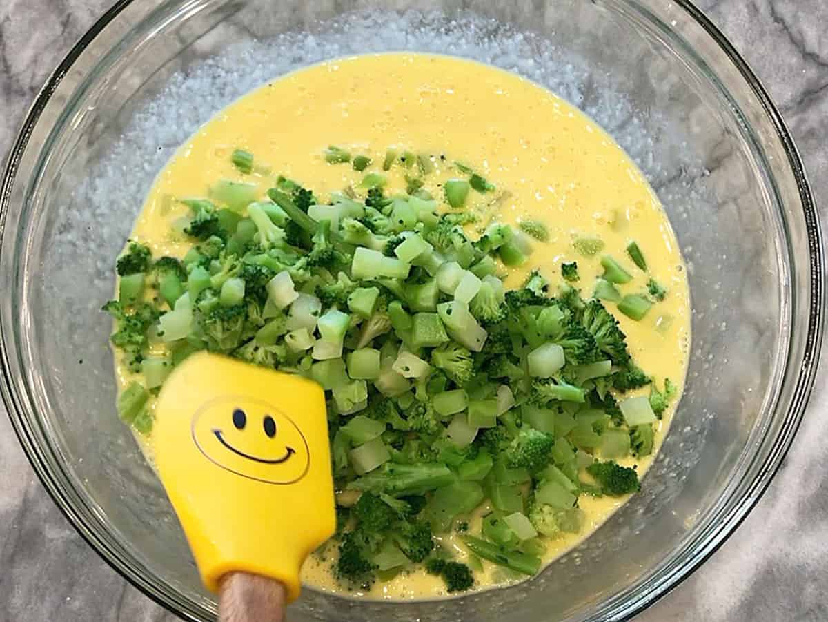 Adding broccoli to the bowl.