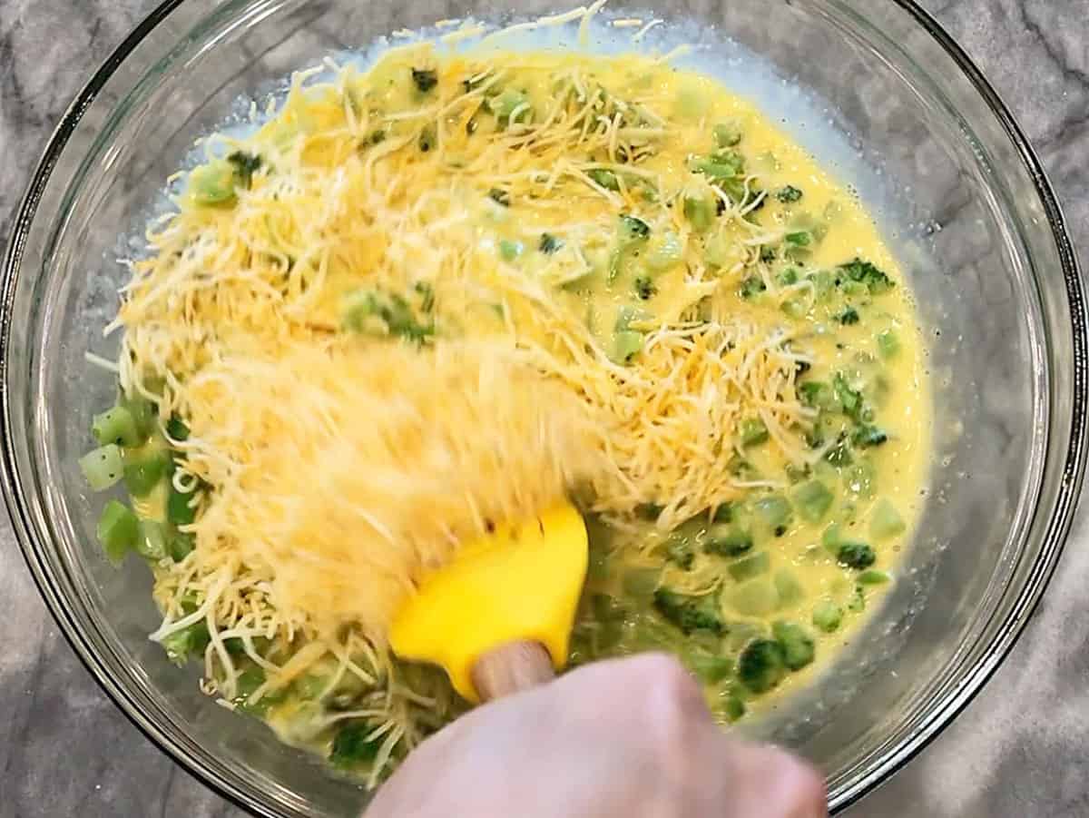Adding cheese to the bowl.