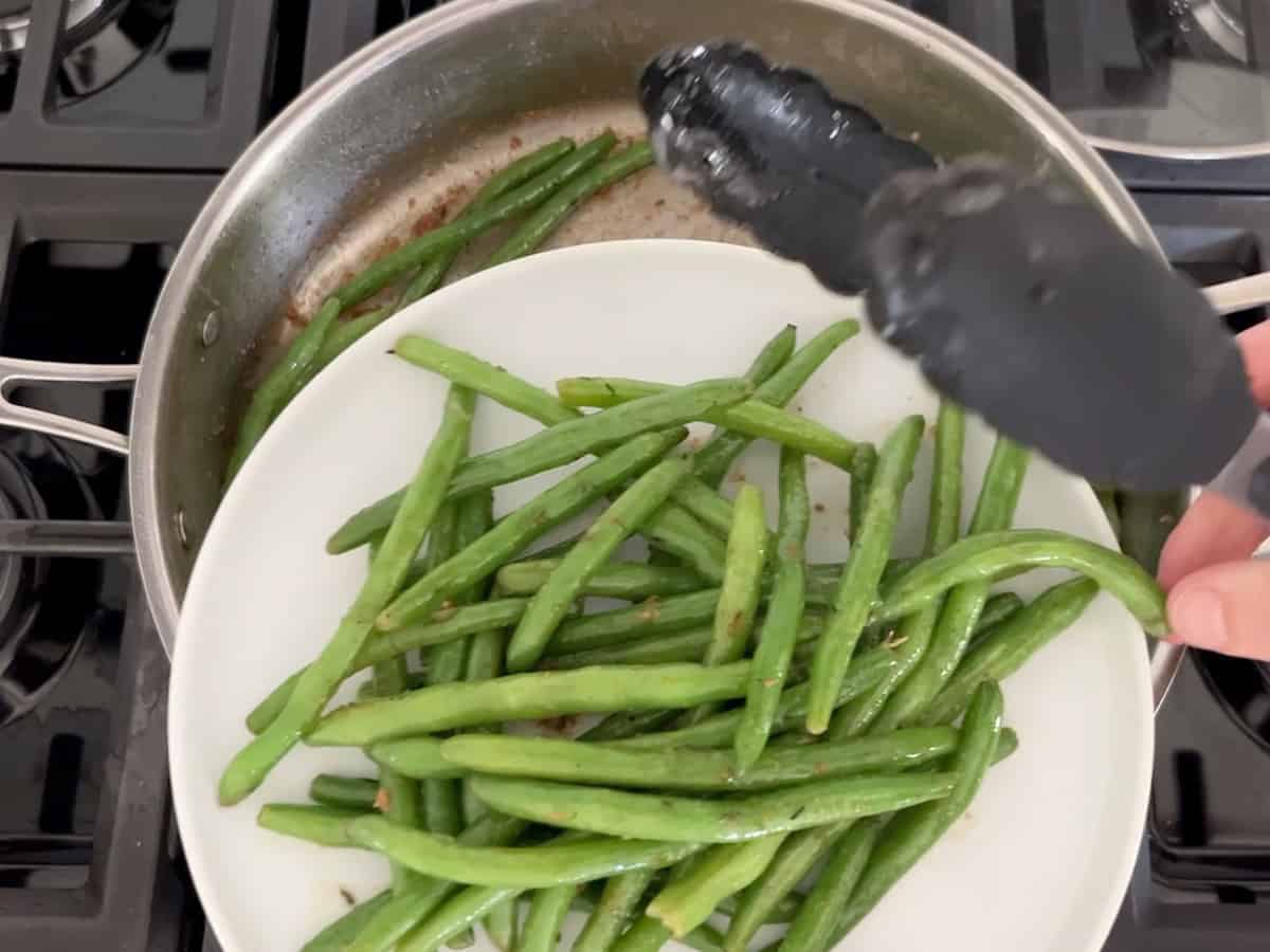 Removing the green beans to a plate.
