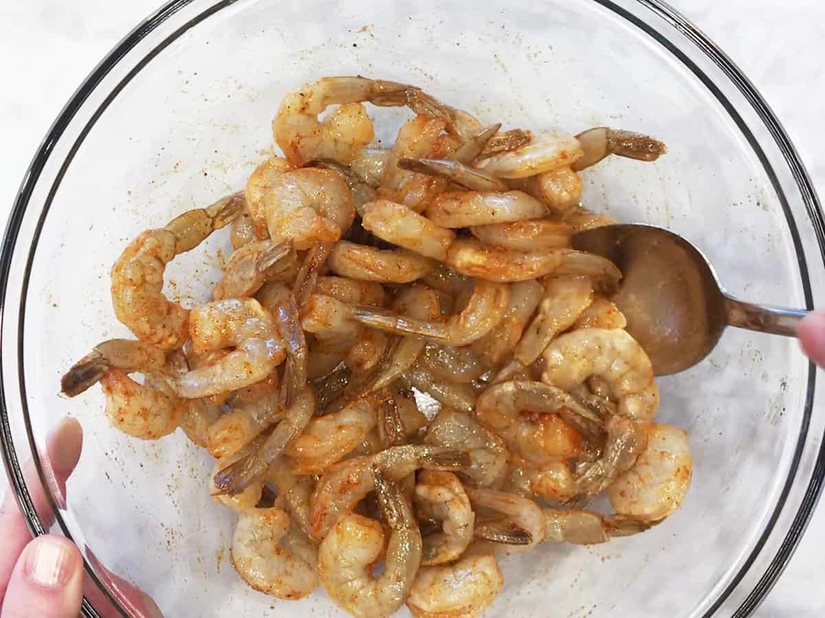 Coating the shrimp in oil and spices. 