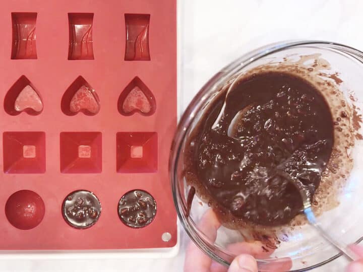 Spooning the chocolate into a candy mold.
