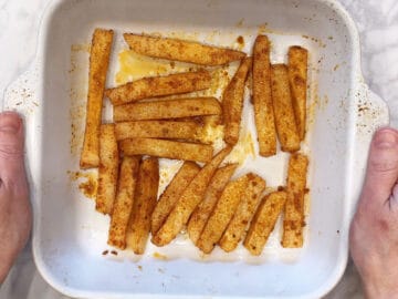 Seasoned jicama sticks are arranged in a baking dish.