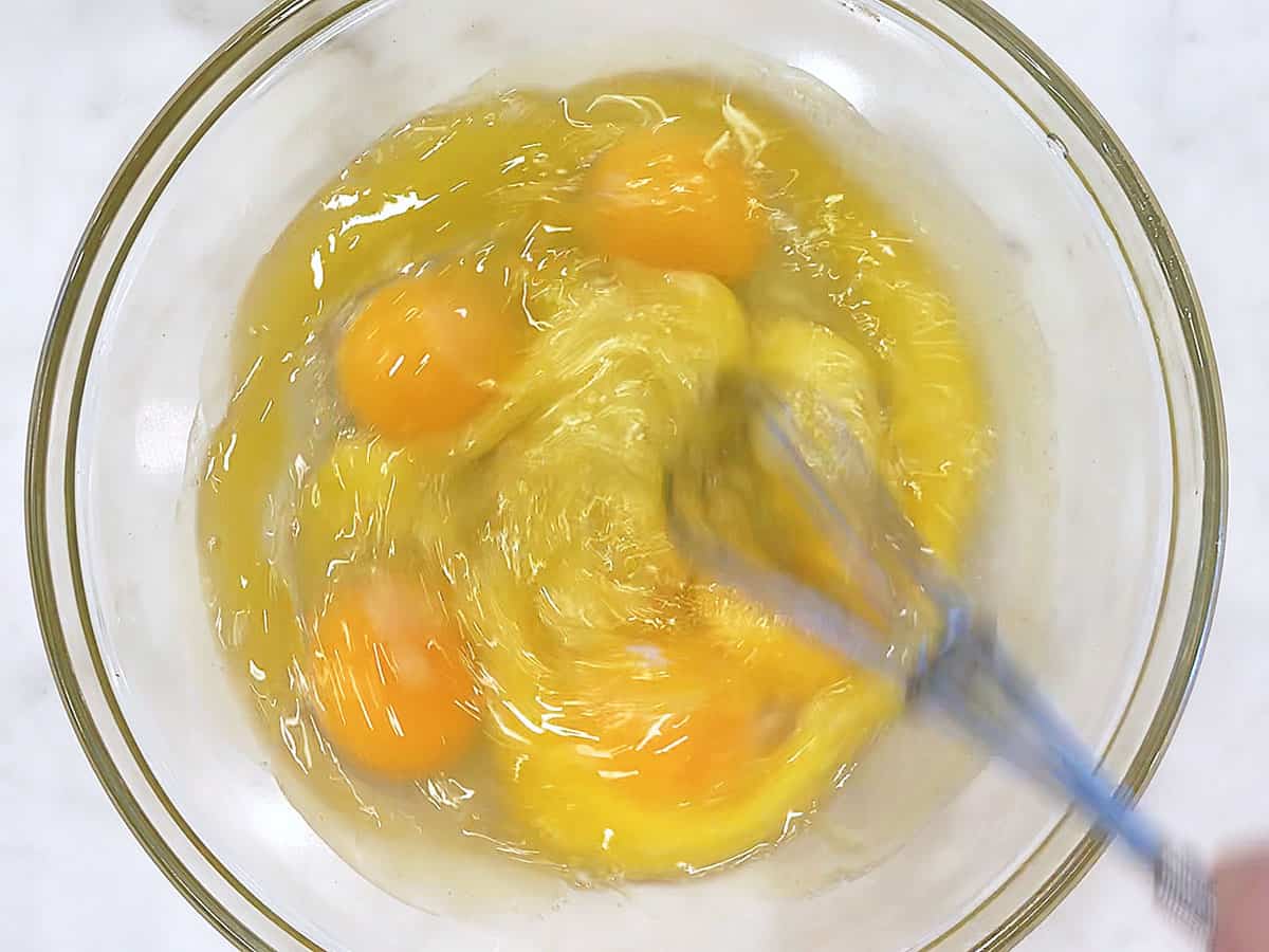 Whisking eggs with stevia and melted butter in a bowl. 