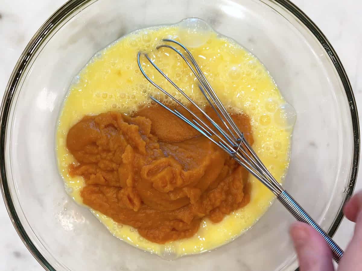 Eggs and pumpkin puree in a bowl.