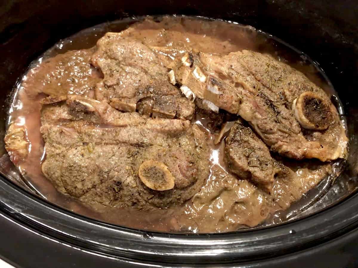 The chops are ready in the slow cooker pan.