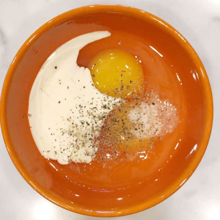 Eggs, milk, salt, and pepper in a bowl.